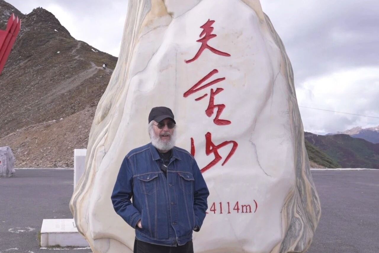 中央民族大学美籍教授马克·力文在雪山弹唱《七律·长征》